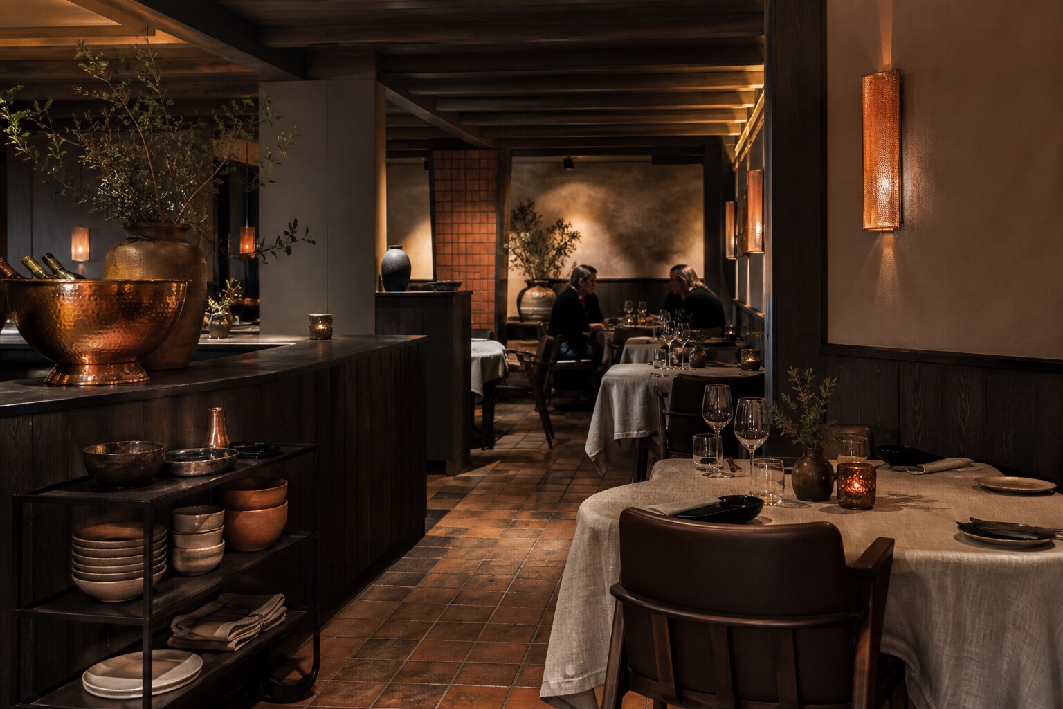 Varm restaurantinnredning i mørkt tre, terrakotta og kobber